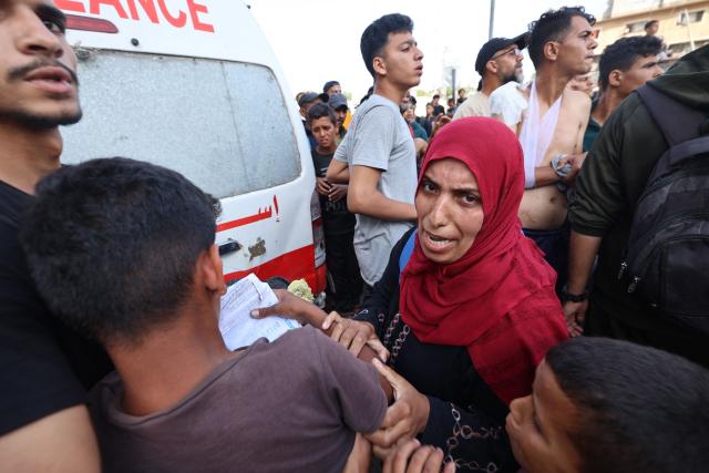 People react as Palestinian rescuers evacuate injured people in an ambulance after an Israeli drone reportedly opened fire on civilian gatherings near an aid distribution point not far from the so-called "Netzarim checkpoint", in the central Gaza Strip, on June 1, 2025, at Bureij camp, amid the war between Israel and the Palestinian Hamas militant movement. (Photo by Eyad BABA / AFP)