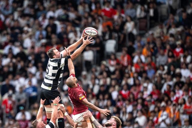 Kubota Spears Funabashi Tokyo Bay's David Bulbring (L) and Toshiba Brave Lupus Tokyo's Michael Leitch compete for the ball during the Rugby League One 2024-25 play-offs final between Toshiba Brave Lupus Tokyo and Kubota Spears Funabashi Tokyo Bay at the National Stadium in Tokyo on June 1, 2025. (Photo by Philip FONG / AFP)