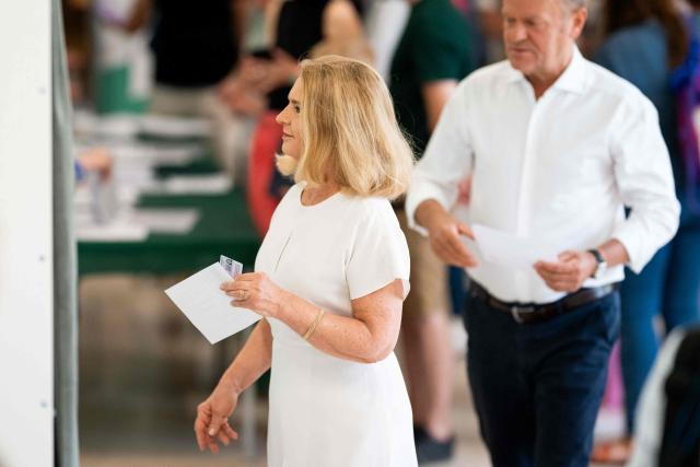 Poland's Prime Minister Donald Tusk (R) and his wife Malgorzata Tusk (L) prepare to cast their ballots at a polling station in Sopot, Poland, during the second round of the presidential elections on June 1, 2025. Polling stations opened for a tight presidential election runoff that will have major implications for the country's role in Europe, and for abortion and LGBTQ rights. Opinion polls have predicted an extremely close race with nationalist historian Karol Nawrocki and pro-EU Warsaw Mayor Rafal Trzaskowski neck and neck ahead of the vote. (Photo by MATEUSZ SLODKOWSKI / AFP)