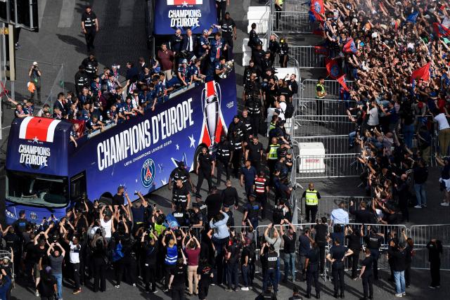 Paris Saint-Germain's supporters wave as the PSG team bus parades on the Champs-Elysees avenue in Paris on June 1, 2025, a day after PSG won the 2025 UEFA Champions League final football match against Inter Milan in Munich. (Photo by Guillaume SOUVANT / AFP)
