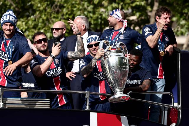 Paris Saint-Germain's French defender #21 Lucas Hernandez (C) holds the UEFA Champions League Trophy during a parade on the Champs-Elysees avenue in Paris on June 1, 2025, a day after PSG won the 2025 UEFA Champions League final football match against Inter Milan in Munich. (Photo by Thibaud MORITZ / AFP)