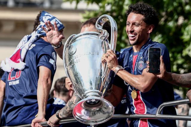 Paris Saint-Germain's Brazilian defender #05 Marquinhos holds the UEFA Champions League Trophy as they parade on the Champs-Elysees avenue in Paris on June 1, 2025, a day after PSG won the 2025 UEFA Champions League final football match against Inter Milan in Munich. (Photo by Thibaud MORITZ / AFP)