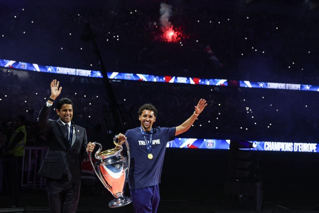 Paris Saint-Germain's Brazilian defender #05 Marquinhos (R) and Paris Saint Germain's Qatari president Nasser al-Khelaifi (L) walk out onto the pitch during a ceremony to present the trophy a day after Paris Saint-Germain (PSG) football club won the UEFA Champions League, at the Parc des Princes Stadium in Paris on June 1, 2025. (Photo by Franck FIFE / AFP)