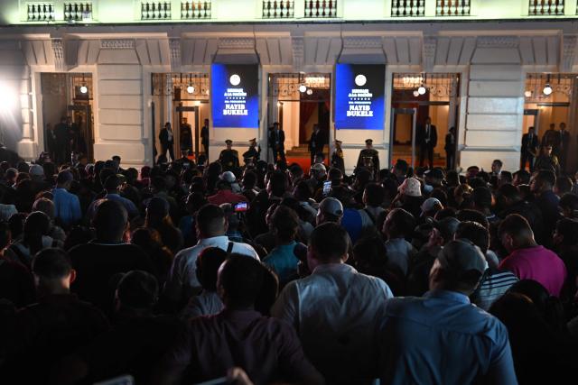 Supporters of El Salvador's President Nayib Bukele listen his first-year speech outside the National Theatre in San Salvador on June 1, 2025. (Photo by Marvin RECINOS / AFP)