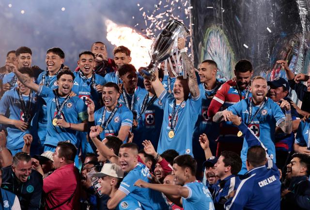 Cruz Azul's Polish midfielder #07 Mateusz Bogusz lifts the trophy next to teammates after winning the CONCACAF Champions Cup final football match between Mexico's Cruz Azul and Canada's Vancouver Whitecaps at the Olimpico Universitario Stadium in Mexico City on June 1, 2025. (Photo by DANIEL GAMEZ GUTIERREZ / AFP)