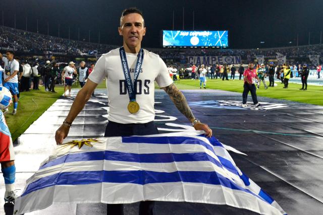 Cruz Azul's Uruguayan interim coach Vicente Sanchez poses with an Uruguayan flag after winning the CONCACAF Champions Cup final football match between Mexico's Cruz Azul and Canada's Vancouver Whitecaps at the Olimpico Universitario Stadium in Mexico City on June 1, 2025. (Photo by Victor CRUZ / AFP)