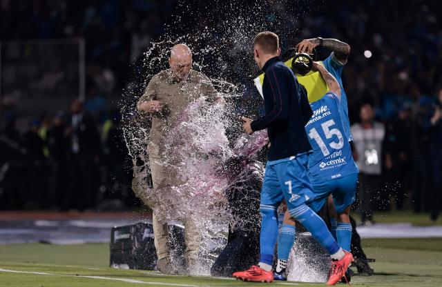 Cruz Azul players pout beberage over Uruguayan interim coach Vicente Sanchez after winning the CONCACAF Champions Cup final football match between Mexico's Cruz Azul and Canada's Vancouver Whitecaps at the Olimpico Universitario Stadium in Mexico City on June 1, 2025. (Photo by DANIEL GAMEZ GUTIERREZ / AFP)
