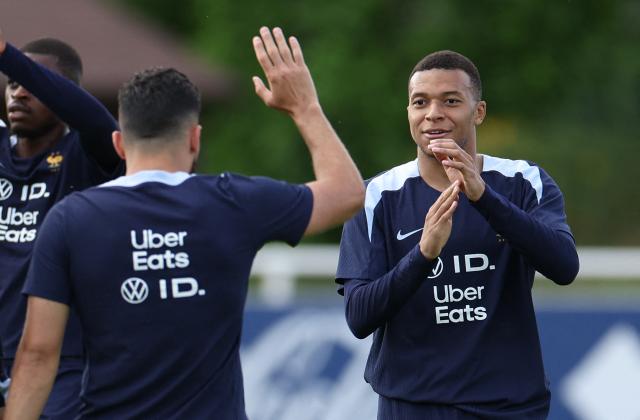 France's forward #10 Kylian Mbappe (R) reacts with a teammate during a training session as part of the team's preparation for the upcoming UEFA Nations League semi-final football match against Spain, in Clairefontaine-en-Yvelines on June 2, 2025. (Photo by FRANCK FIFE / AFP)