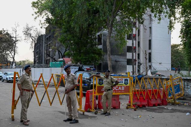 Policemen stand guard at the crash site of Air India flight 171, at a residential area near the airport in Ahmedabad on June 14, 2025, after the Boeing 787-8 aircraft crashed shortly after taking off on June 12. Investigators recovered a black box recorder on June 13 from the crash site of a London-bound passenger jet that ploughed into a residential area of India's Ahmedabad city, killing at least 265 people on board and on the ground. (Photo by Punit PARANJPE / AFP)