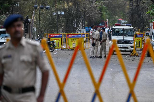 Policemen stand guard at the crash site of Air India flight 171, at a residential area near the airport in Ahmedabad on June 14, 2025, after the Boeing 787-8 aircraft crashed shortly after taking off on June 12. Investigators recovered a black box recorder on June 13 from the crash site of a London-bound passenger jet that ploughed into a residential area of India's Ahmedabad city, killing at least 265 people on board and on the ground. (Photo by Punit PARANJPE / AFP)