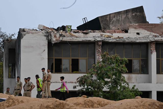 Policemen stand guard at the crash site of Air India flight 171 at a residential area near the airport in Ahmedabad on June 14, 2025, after the Boeing 787-8 aircraft crashed shortly after taking off on June 12. Investigators recovered a black box recorder on June 13 from the crash site of a London-bound passenger jet that ploughed into a residential area of India's Ahmedabad city, killing at least 265 people on board and on the ground. (Photo by Punit PARANJPE / AFP)