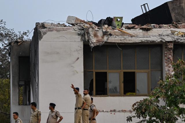 Policemen stand guard at the crash site of Air India flight 171 at a residential area near the airport in Ahmedabad on June 14, 2025, after the Boeing 787-8 aircraft crashed shortly after taking off on June 12. Investigators recovered a black box recorder on June 13 from the crash site of a London-bound passenger jet that ploughed into a residential area of India's Ahmedabad city, killing at least 265 people on board and on the ground. (Photo by Punit PARANJPE / AFP)
