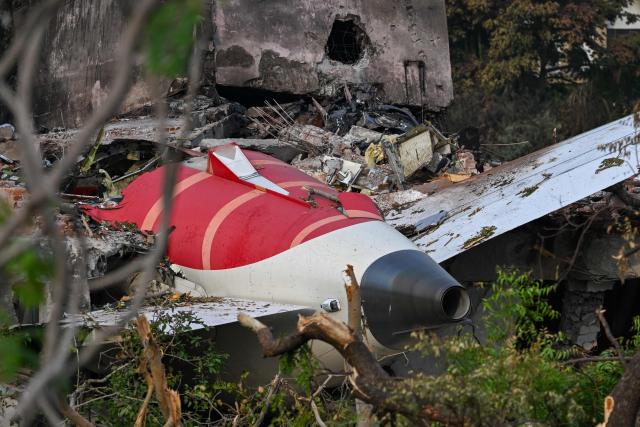 Wreckage showing the tail section of the Air India Boeing 787-8 is pictured in a residential area near the airport in Ahmedabad on June 14, 2025, after the aircraft operating as flight 171 crashed shortly after taking off on June 12. Investigators recovered a black box recorder on June 13 from the crash site of a London-bound passenger jet that ploughed into a residential area of India's Ahmedabad city, killing at least 265 people on board and on the ground. (Photo by Punit PARANJPE / AFP)