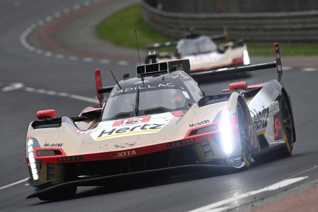 Cadillac Hertz Team Jota's British driver #12 Will Stevens (front) steers his hypercar in front of Cadillac Hertz Team Jota's New Zealand driver #38 Earl Bamber during the 2025 Le Mans 24 hour endurance race, at the Le Mans circuit, in north-western France on June 14, 2025. (Photo by JEAN-FRANCOIS MONIER / AFP)
