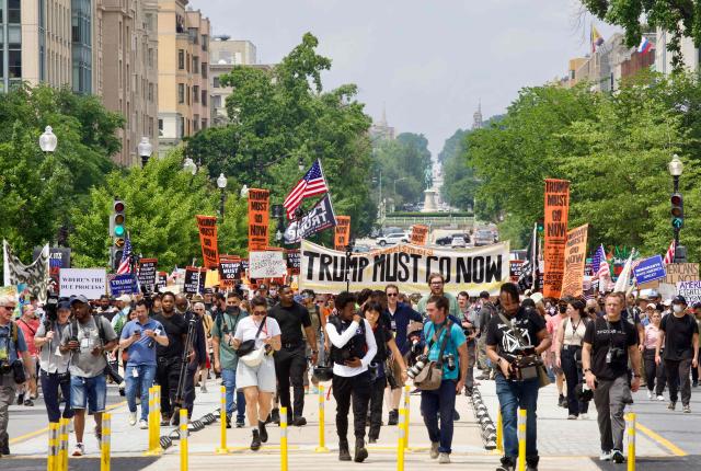 Protesters rally at Lafayette Square during the "No Kings" protest in Washington, DC, on June 14, 2025, the day of President Trump's military parade. In response to the military parade celebrating the 250th anniversary of the US Army but also coinciding with Trump's 79th birthday, a "No Kings" movement has sprung up promising to stage protests in more than 2,000 places across the country, including a large parade expected in Los Angeles which organizers say will feature a "20-foot-tall balloon of Trump wearing a diaper." (Photo by Amid FARAHI / AFP)