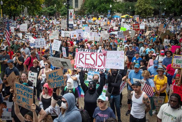 Protesters take part in a nationwide "No Kings" rally in downtown Louisville, Kentucky, on June 14, 2025, on the same day as President Donald Trump's military parade in Washington, DC. Thousands of people rallied across the United States on June 14 as a so-called "No Kings" has sprung up against the policies of US President Donald Trump, ahead of a rare military parade on his 79th birthday. (Photo by LEANDRO LOZADA / AFP)