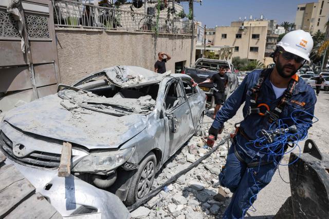 A member of the search and rescue teams works in a neighbourhood in the northern Israeli village of Tamra, following an overnigh missile attack from Iran on June 15, 2025, where four people, including a child, were reported killed. Iranian missile fire on Israel killed at least 10 people overnight, authorities said on June 15, as the foes exchanged new waves of attacks in their most intense confrontation in history. (Photo by AHMAD GHARABLI / AFP)