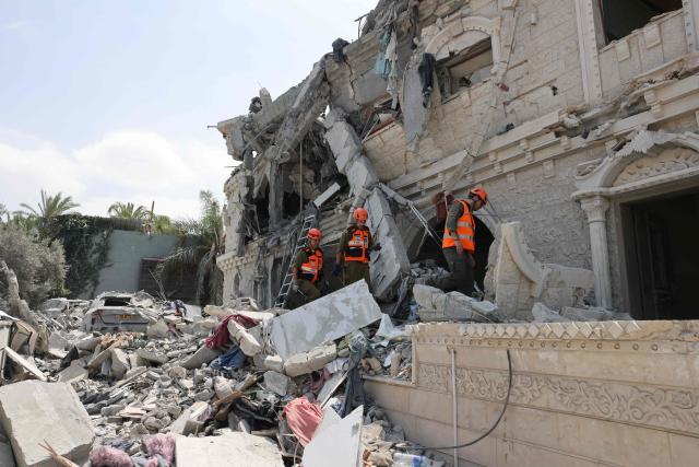 Members of the search and rescue team check the rubble of a damaged building in the northern Israeli village of Tamra, following an overnigh missile attack from Iran on June 15, 2025, where four people, including a child, were reported killed. Iranian missile fire on Israel killed at least 10 people overnight, authorities said on June 15, as the foes exchanged new waves of attacks in their most intense confrontation in history. (Photo by AHMAD GHARABLI / AFP)