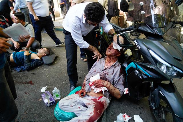 TOPSHOT - Iranians care for people who were injured in a reported Israeli strike on Keshavarz Boulevard in downtown Tehran on June 15, 2025. Israel and Iran traded heavy fire for a third straight day on June 15, with mounting casualties and expanding targets marking a sharp escalation in hostilities between the longtime foes. (Photo by AMIR KHOLOUSI / ISNA / AFP)