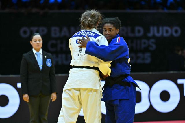 Uzbekistan's Shukurjon Aminova congratulates France's Sarah Leonie Cysique (blue) after the women's -57kg bronze match of the Judo World Championships at the Papp Laszlo Arena in Budapest, Hungary on June 15, 2025. (Photo by Attila KISBENEDEK / AFP)