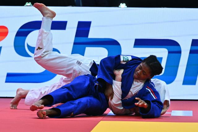 Uzbekistan's Shukurjon Aminova competes against France's Sarah Leonie Cysique (blue) in the women's -57kg bronze match of the Judo World Championships at the Papp Laszlo Arena in Budapest, Hungary on June 15, 2025. (Photo by Attila KISBENEDEK / AFP)