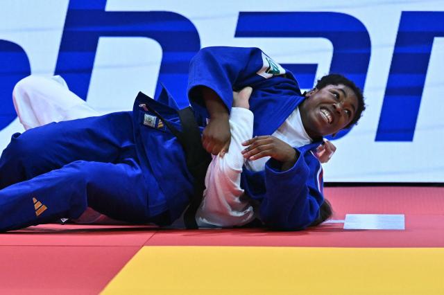 Uzbekistan's Shukurjon Aminova competes against France's Sarah Leonie Cysique (blue) in the women's -57kg bronze match of the Judo World Championships at the Papp Laszlo Arena in Budapest, Hungary on June 15, 2025. (Photo by Attila KISBENEDEK / AFP)