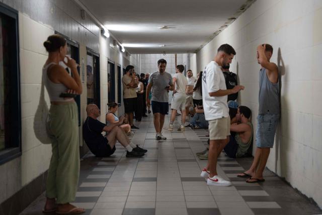 Israelis take shelter during a missile siren alert in Haifa, on June 16, 2025. Israel and Iran traded deadly fire for a fourth day on June 16 in their most intense confrontation in history, fuelling fears of a drawn-out conflict that could engulf the Middle East. (Photo by Maya Levin / AFP)