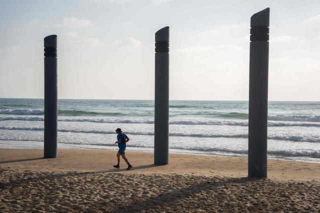 A man exercises on the beach in Haifa, on June 16, 2025. Israel and Iran traded deadly fire for a fourth day on June 16 in their most intense confrontation in history, fuelling fears of a drawn-out conflict that could engulf the Middle East. (Photo by Maya Levin / AFP)