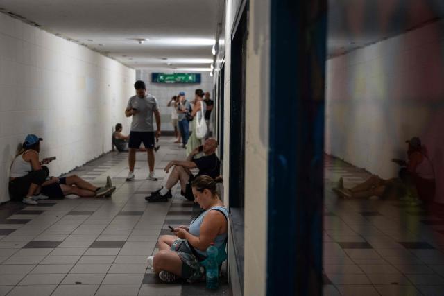 Israelis take shelter during a missile siren alert in Haifa, on June 16, 2025. Israel and Iran traded deadly fire for a fourth day on June 16 in their most intense confrontation in history, fuelling fears of a drawn-out conflict that could engulf the Middle East. (Photo by Maya Levin / AFP)