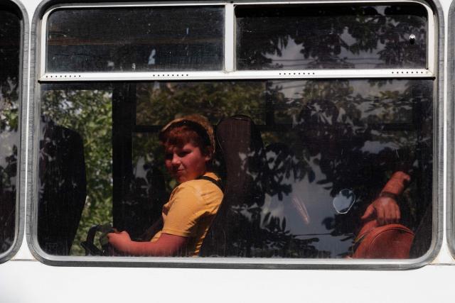 A boy looks out from the window of an evacuation bus in Mezhova, in Dnipropetrovsk Region on June 17, 2025, amid the Russian invasion of Ukraine. (Photo by Tetiana DZHAFAROVA / AFP)