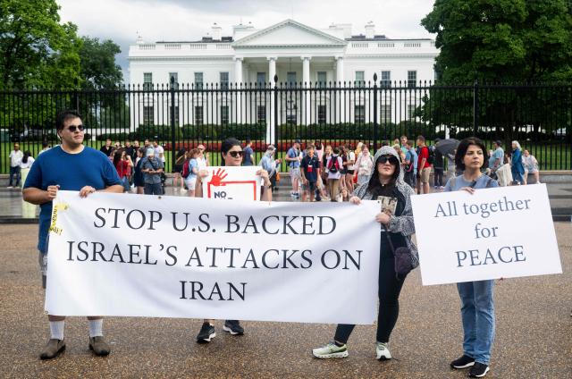 People hold a banner as they protest the Israeli strikes on Iran and any potential US involvement in the conflict during a "No War on Iran" demonstration outside the White House in Washington, DC, on June 18, 2025. US President Donald Trump said on June 18 that he was still deciding whether to join Israel's strikes on Iran, claiming Tehran now wants talks at the White House but may have waited too long. (Photo by SAUL LOEB / AFP)