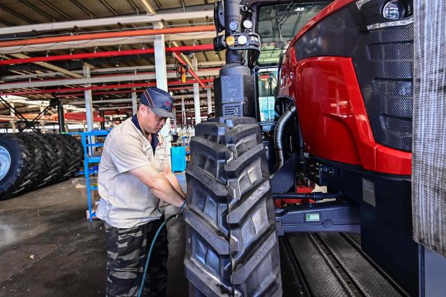 An employee works on a tractor assembly line at a factory in Qingzhou, in eastern China's Shandong province on June 27, 2025. (Photo by AFP) / China OUT