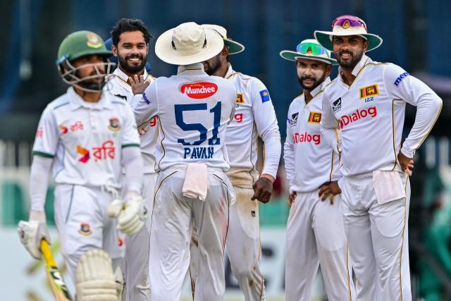 Sri Lanka's captain Dhananjaya de Silva (2L) celebrates with teammates after taking the wicket of Bangladesh's Mominul Haque (L) during the third day of the second Test cricket match between Sri Lanka and Bangladesh at the Sinhalese Sports Club (SSC) Ground in Colombo on June 27, 2025. (Photo by Ishara S. KODIKARA / AFP)