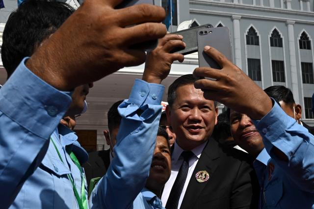Cambodia's Prime Minister Hun Manet (C) poses for a picture with supporters during a ceremony marking the 74th founding anniversary of the Cambodian People’s Party (CPP) in Phnom Penh on June 28, 2025. (Photo by TANG CHHIN Sothy / AFP)