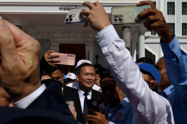 Cambodia's Prime Minister Hun Manet (C) poses for a picture with supporters during a ceremony marking the 74th founding anniversary of the Cambodian People’s Party (CPP) in Phnom Penh on June 28, 2025. (Photo by TANG CHHIN Sothy / AFP)
