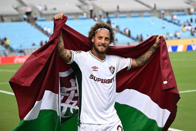 Fluminense's Brazilian defender #23 Guga holds a Fluminense Club flag as he celebrates his team's victory at the end of the FIFA Club World Cup 2025 round of 16 football match between Italy's Inter Milan and Brazil's Fluminense at the Bank of America Stadium in Charlotte on June 30, 2025. (Photo by Paul ELLIS / AFP)