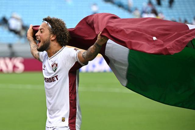 Fluminense's Brazilian defender #23 Guga waves a Fluminense Club fag as he celebrates his team's victory at the end of the FIFA Club World Cup 2025 round of 16 football match between Italy's Inter Milan and Brazil's Fluminense at the Bank of America Stadium in Charlotte on June 30, 2025. (Photo by Paul ELLIS / AFP)