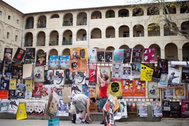 (FILES) Artists of the Festival Off Avignon theatre event hang posters to promote their plays in Avignon on July 5, 2016. There is an abundance of companies and performances at the 2025 edition of the Festival Off Avignon, but this record edition masks an industry suffering from budget cuts and the crisis in the distribution of performances, say organisers and industry stakeholders. (Photo by BERTRAND LANGLOIS / AFP)