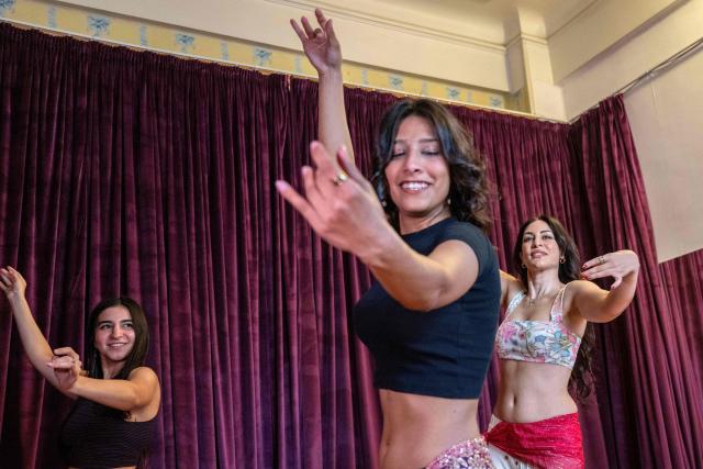 Egyptian belly-dancer Amie Sultan (R), dancer Safaa Said (L), and dancer Menna Emmam (C), full-time instructors at the Taksim Belly-dance Institute, take part in a rehearsal in Cairo on April 12, 2025. As belly dancing gains popularity internationally, young Egyptian performers are working to restore its reputation at home, pushing back against decades of stigma to reclaim the dance as part of their artistic heritage. Once iconic figures of Egypt's cinematic golden age, belly dancers have watched their prestige wane, their art increasingly confined to nightclubs and wedding halls. (Photo by Khaled DESOUKI / AFP)