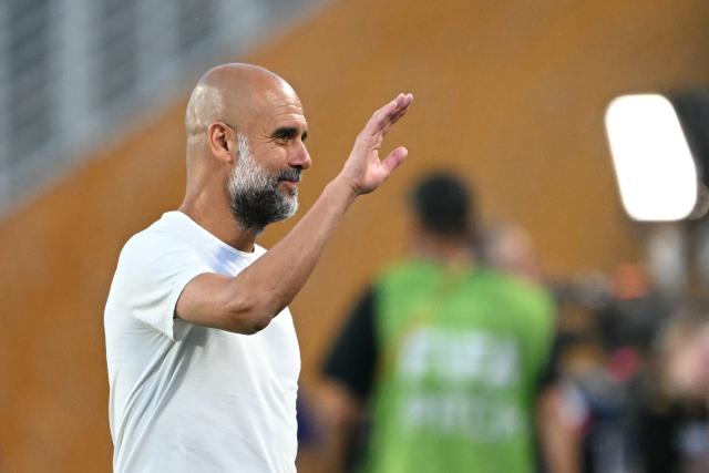 Manchester City's Spanish head coach Pep Guardiola waves during the warmup ahead of the FIFA Club World Cup 2025 round of 16 football match between England's Manchester City and Saudi's Al-Hilal at the Camping World stadium in Orlando on June 30, 2025. (Photo by PATRICIA DE MELO MOREIRA / AFP)