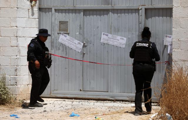 Municipal police officers remain outside the crematorium where authorities found 381 corpses embalmed in Ciudad Juarez, Chihuahua State, Mexico, on June 30, 2025. Police have found 381 corpses piled up in a private crematorium in northern Mexico's Ciudad Juarez, the local prosecutor's office said on June 29, attributing the grisly find to negligence. (Photo by Herika Martinez / AFP)