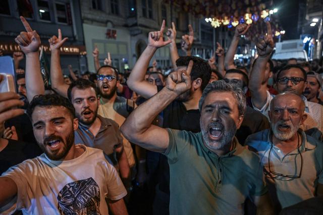 Islamist protesters shout slogans against cartoonists as they gather at Istiklal avenue near Leman Magazine  n Istanbul on June 30, 2025. Clashes erupted in Istanbul Monday with police firing rubber bullets and tear gas to break up an angry mob after allegations that a satirical magazine had published a cartoon of the Prophet Mohammed, an AFP correspondent said. The incident occurred after Istanbul's chief prosecutor ordered the arrest of the editors at LeMan magazine on grounds it had published a cartoon which "publicly insulted religious values". (Photo by Ozan KOSE / AFP)