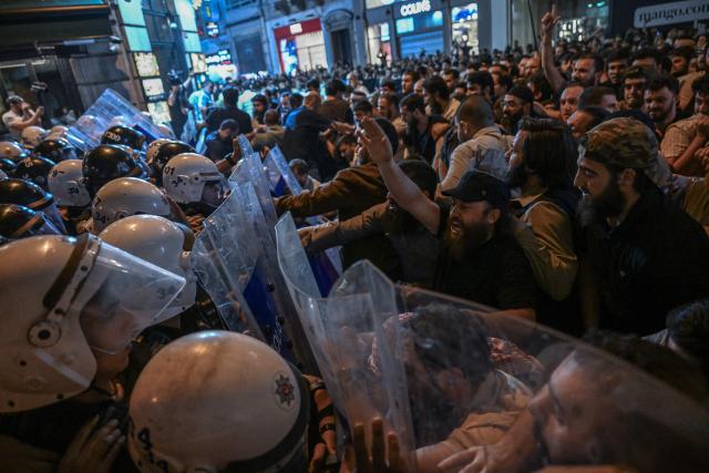 Islamist protesters clash with Turkish anti riot police officers as they gather to protests Leman cartoon magazine in Istanbul on June 30, 2025. Clashes erupted in Istanbul Monday with police firing rubber bullets and tear gas to break up an angry mob after allegations that a satirical magazine had published a cartoon of the Prophet Mohammed, an AFP correspondent said. The incident occurred after Istanbul's chief prosecutor ordered the arrest of the editors at LeMan magazine on grounds it had published a cartoon which "publicly insulted religious values". (Photo by Ozan KOSE / AFP)