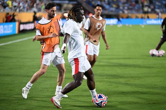 Manchester City's Belgian midfielder #11 Jeremy Doku and teammate French midfielder #29 Rayan Cherki fight for the ball during the warmup ahead of the FIFA Club World Cup 2025 round of 16 football match between England's Manchester City and Saudi's Al-Hilal at the Camping World stadium in Orlando on June 30, 2025. (Photo by PATRICIA DE MELO MOREIRA / AFP)