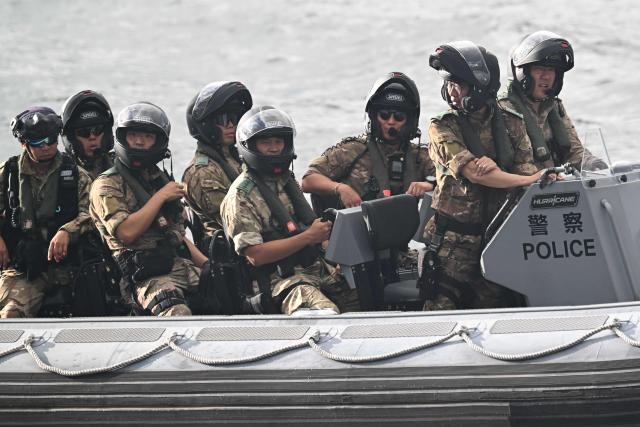 A police boat keeps watch in Victoria Harbour during a flag-raising ceremony to mark the 28th anniversary of Hong Kong's handover from Britain to China in Hong Kong on July 1, 2025. (Photo by Peter PARKS / AFP)