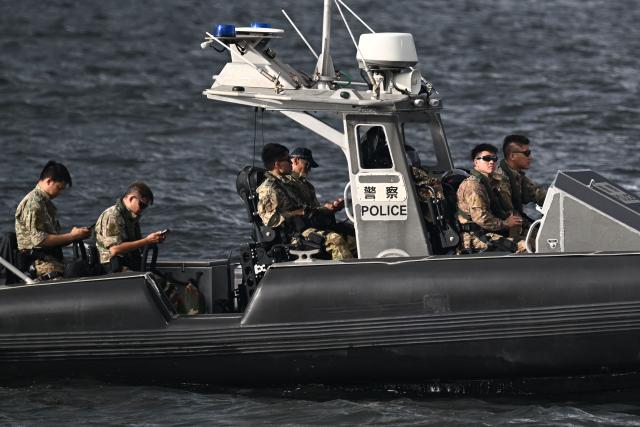 A police boat keeps watch in Victoria Harbour during a flag-raising ceremony to mark the 28th anniversary of Hong Kong's handover from Britain to China in Hong Kong on July 1, 2025. (Photo by Peter PARKS / AFP)