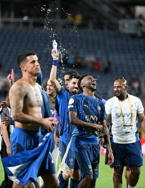 Al-Hilal players celebrate after winning the FIFA Club World Cup 2025 round of 16 football match between England's Manchester City and Saudi's Al-Hilal at the Camping World stadium in Orlando on June 30, 2025. (Photo by Chandan Khanna / AFP)