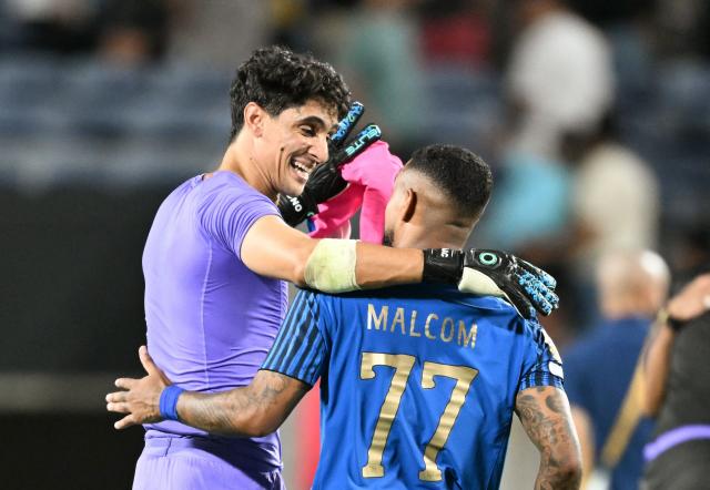 Al Hilal's Moroccan goalkeeper #37 Yassine Bounou and Brazilian forward #77 Malcom  celebrate after winning the FIFA Club World Cup 2025 round of 16 football match between England's Manchester City and Saudi's Al-Hilal at the Camping World stadium in Orlando on June 30, 2025. (Photo by CHANDAN KHANNA / AFP)