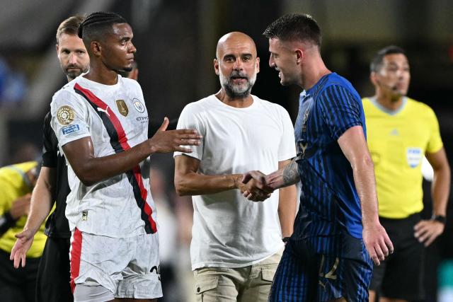 Manchester City's Spanish head coach Pep Guardiola greets Al Hilal's Serbian midfielder #22 Sergej Milinkovic-Savic next to Manchester City's Swiss defender #25 Manuel Akanji at the end of the FIFA Club World Cup 2025 round of 16 football match between England's Manchester City and Saudi's Al-Hilal at the Camping World stadium in Orlando on June 30, 2025. (Photo by PATRICIA DE MELO MOREIRA / AFP)