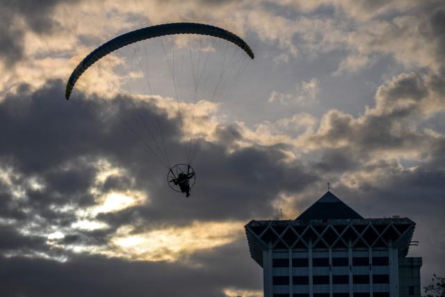 A police officer parasails ahead of the 79th anniversary celebration of the Indonesian National Police held at the National Monument (known as Monas) in Jakarta on July 1, 2025. (Photo by BAY ISMOYO / AFP)